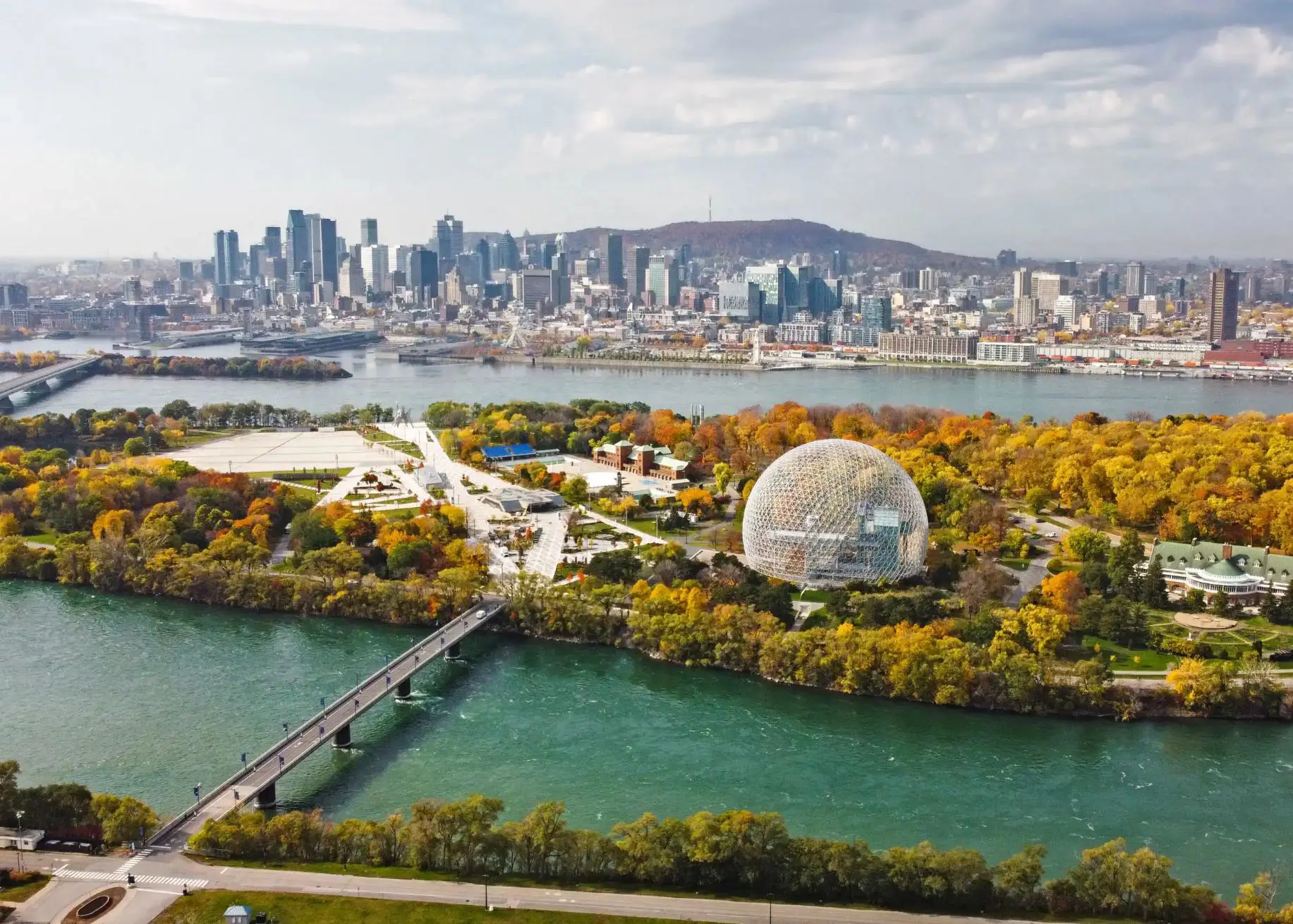 Aerial view of Montreal with the Biosphere and city skyline, surrounded by colourful autumn foliage and the St. Lawrence River