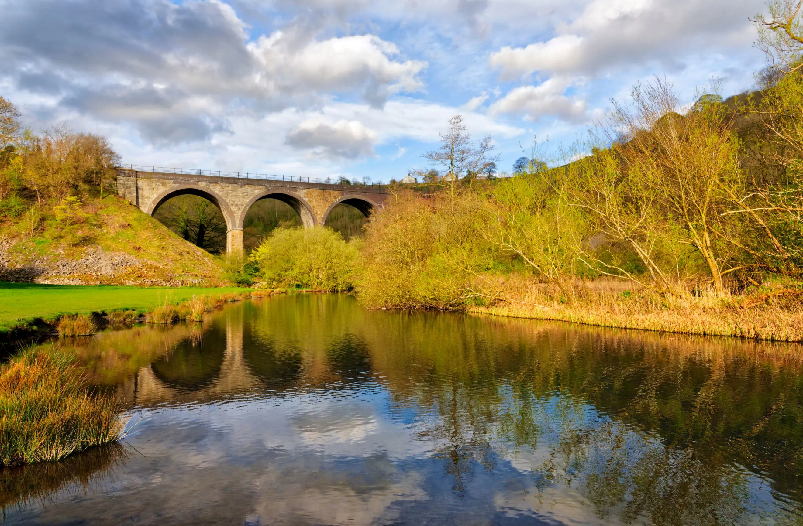 Shot of Headstone Viaduct and the river, with trees either side