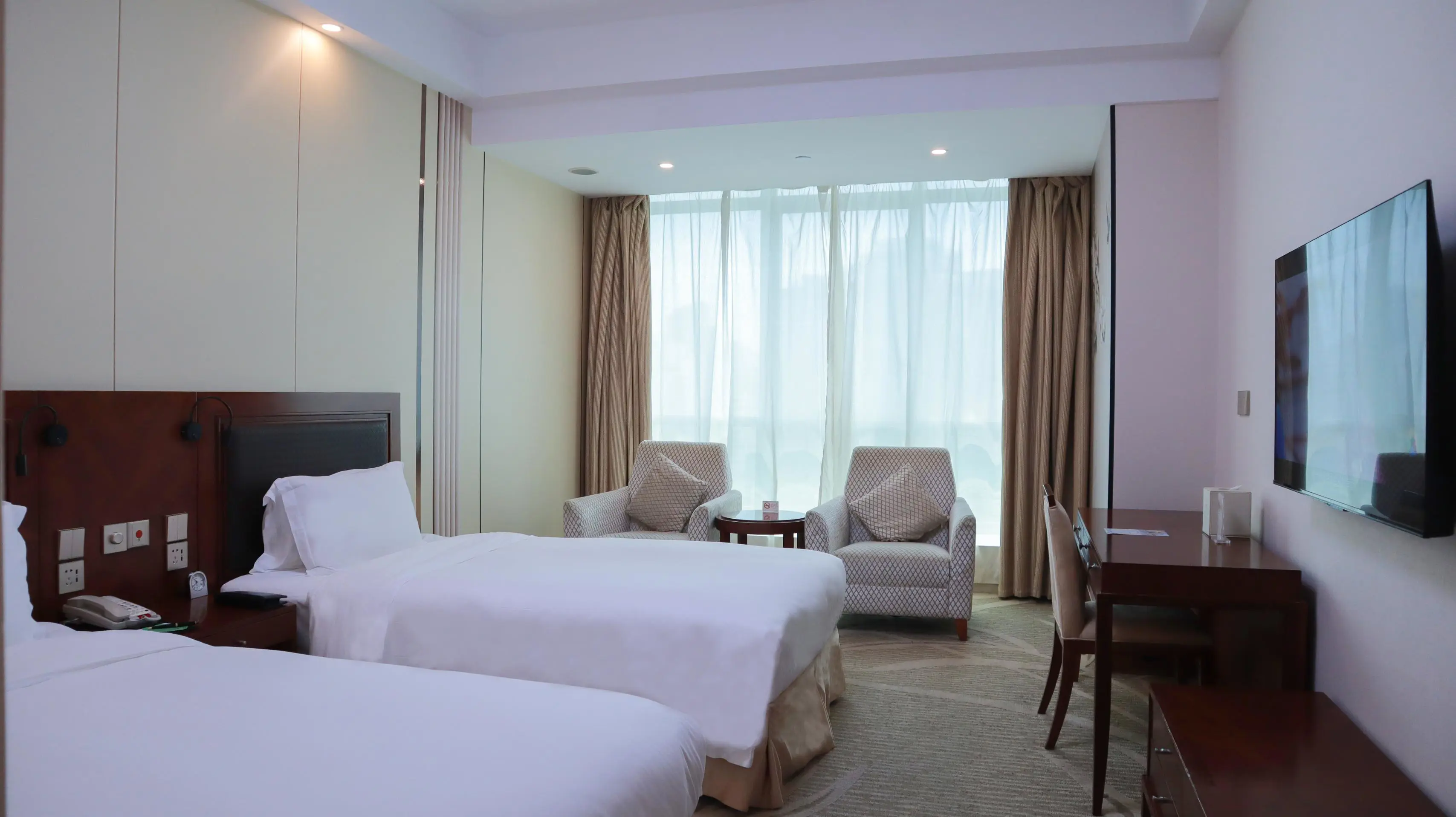 Sleek twin room with two beds, flat-screen TV and a seating area by the floor-to-ceiling windows at the Shanghai Metropark Jichen Hotel in Shanghai, China
