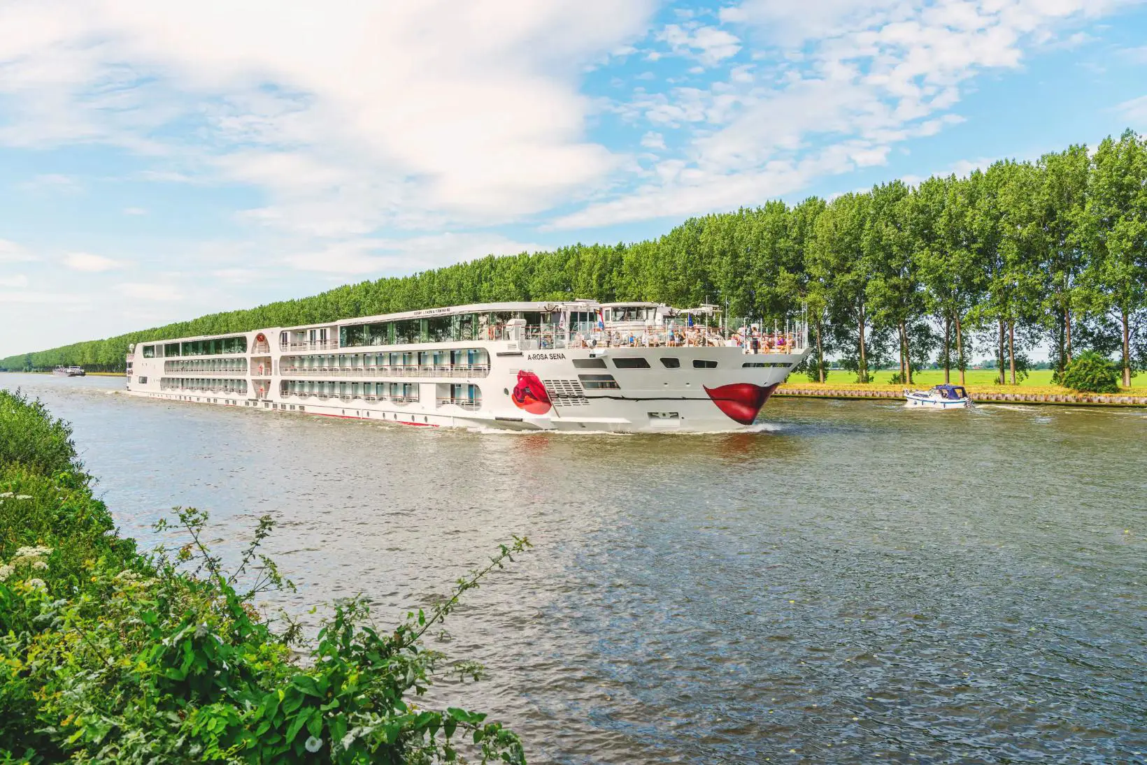 The A-ROSA SENA river cruise ship on a calm river, showcasing its modern exterior against a scenic backdrop
