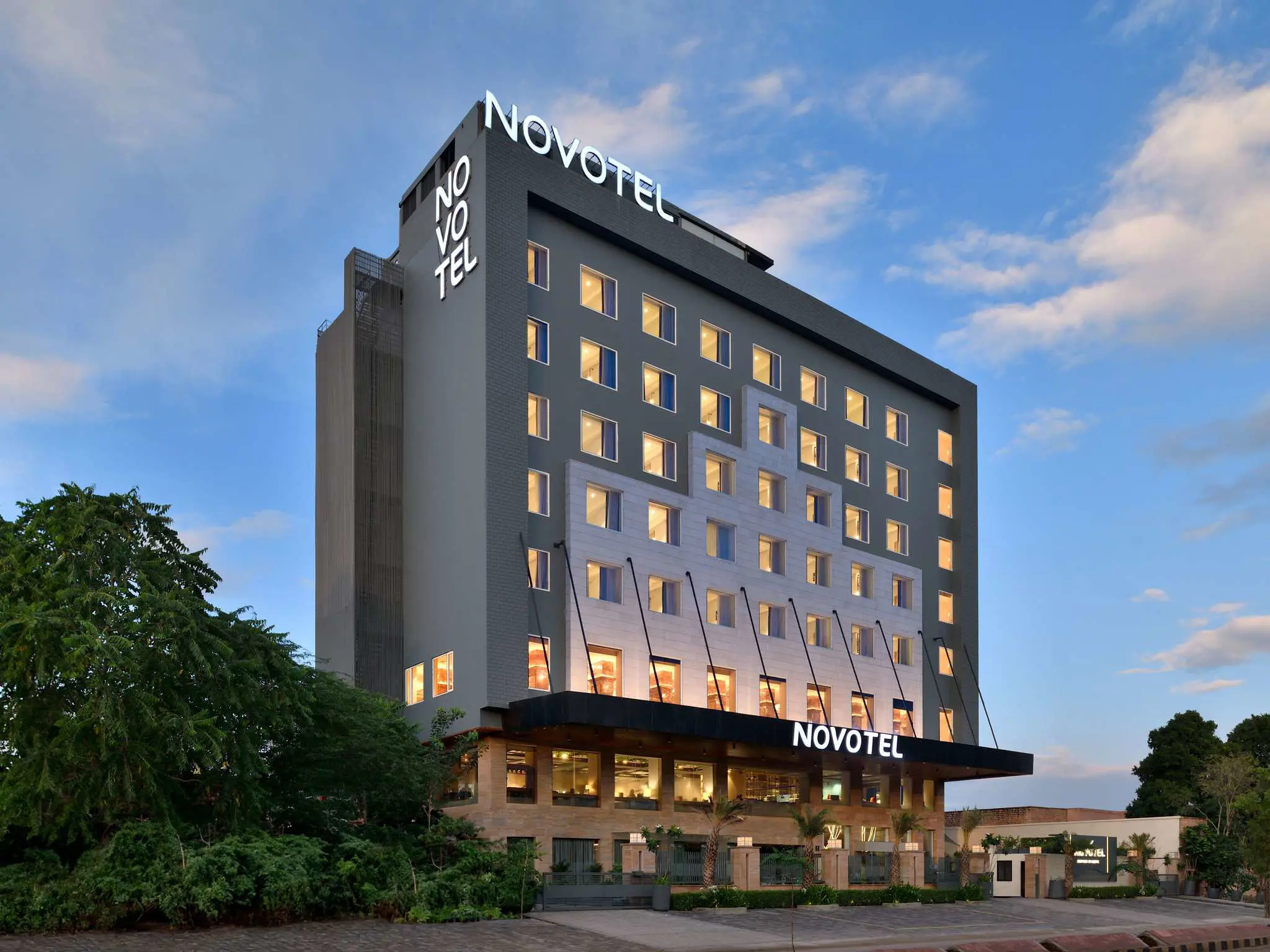 Exterior of Novotel Jodhpur, a modern grey and white building with large windows and a landscaped entrance