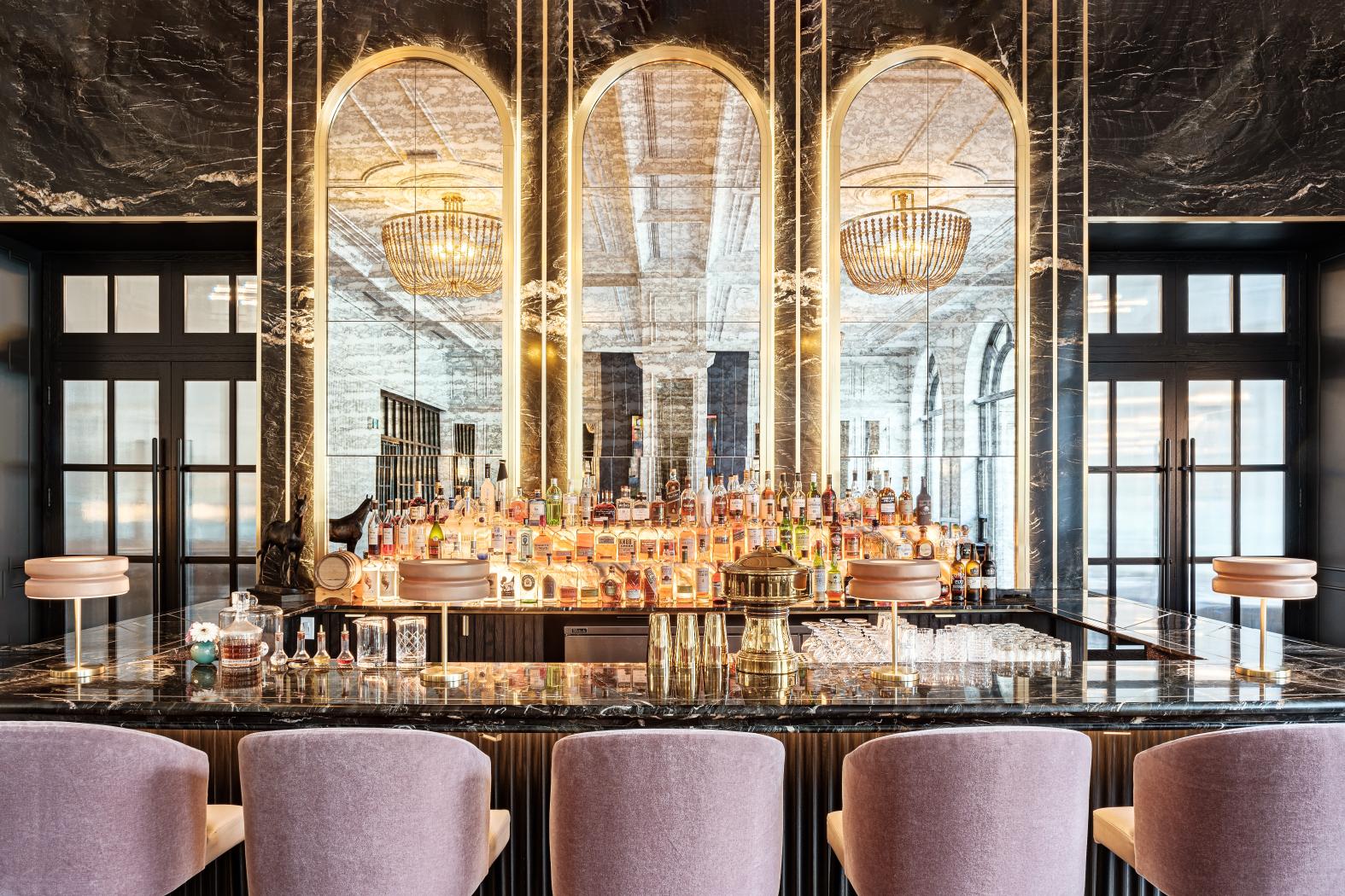 Elegant marble bar at Fairmont Chateau hotel with mirrored arches and a wide selection of spirits