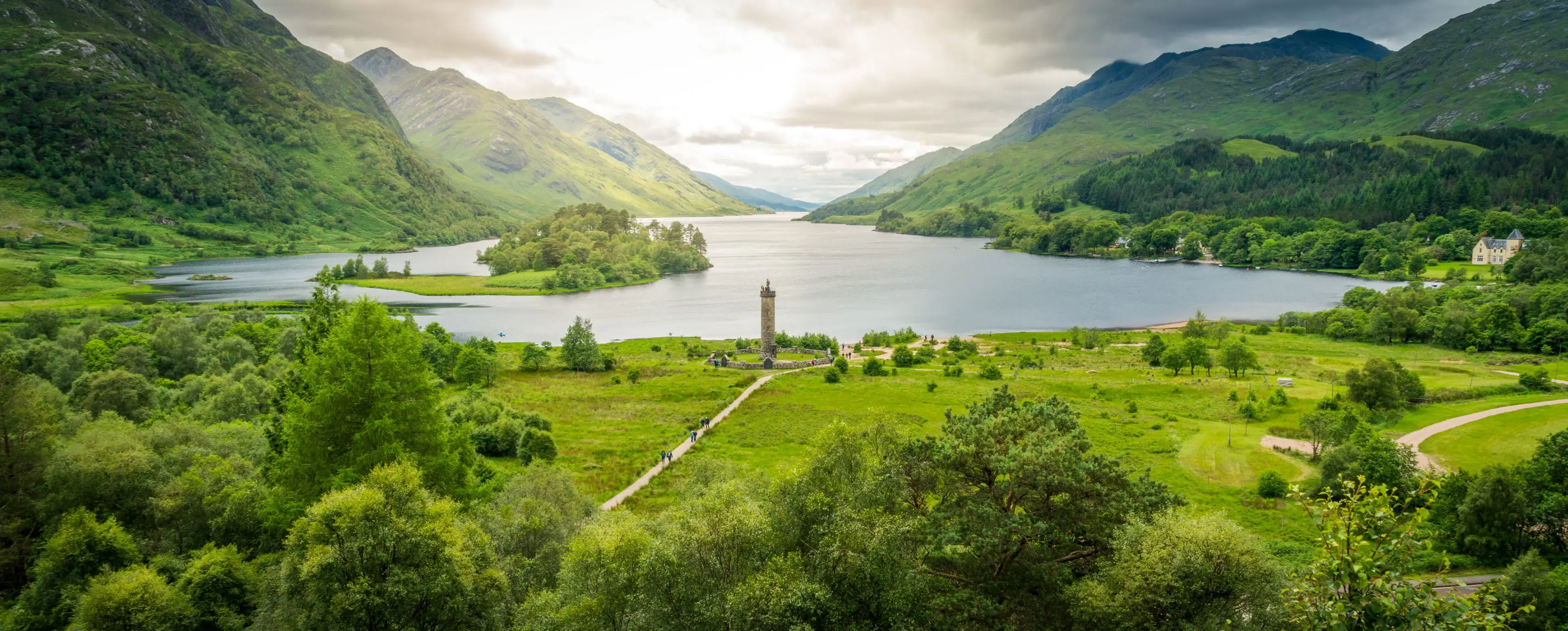 Zoomed out image of Glenfinnan Monument, with the view of Loch Shiel and the surrounding mountains