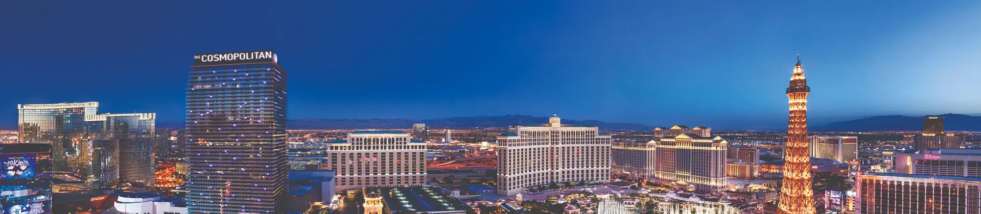 Aerial view of Las Vegas at night, with a dazzling display of colourful neon lights, illuminated streets, and iconic casinos glowing against the dark sky