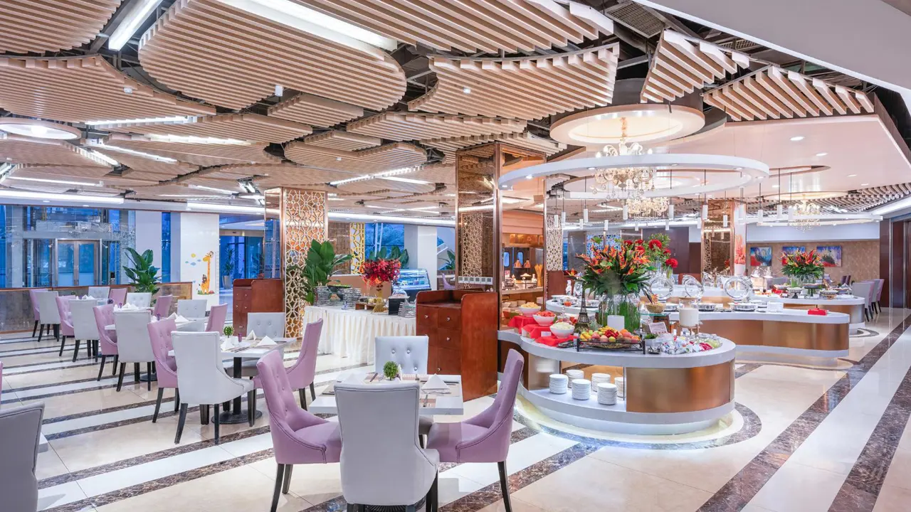 Modern hotel restaurant with elegant lighting, floral centrepieces and neatly set tables at the Mercure Beijing Downtown Hotel in Beijing, China