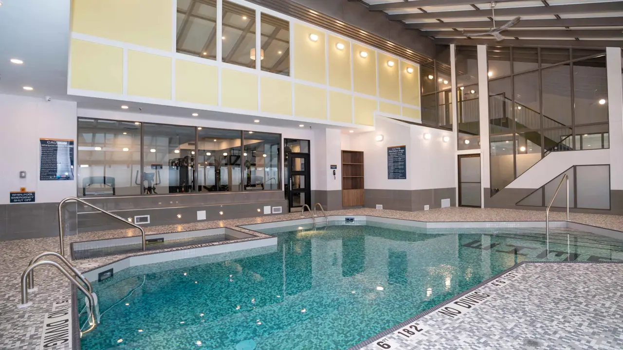 The indoor pool at Sandman Signature Calgary Downtown, Calgary, in a unique architectural space with bright lighting and a modern, clean style