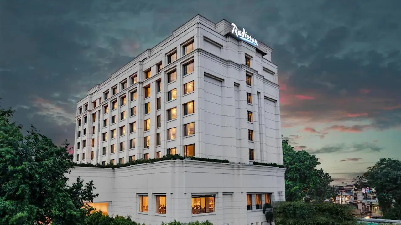 The multi-storey Radisson Hotel in Varanasi lit warmly against an evening sky
