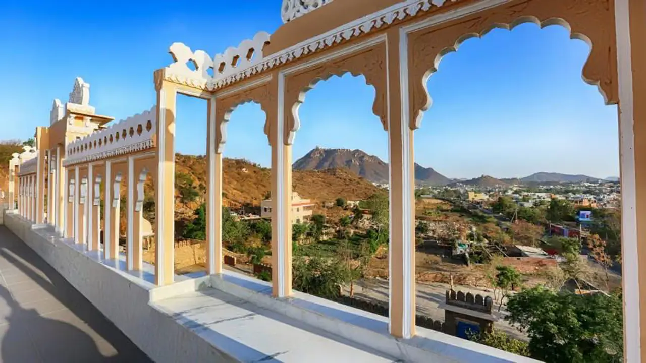 Arched terrace at Fateh Niwas Hotel, Udaipur, framing scenic views of surrounding hills and the city below