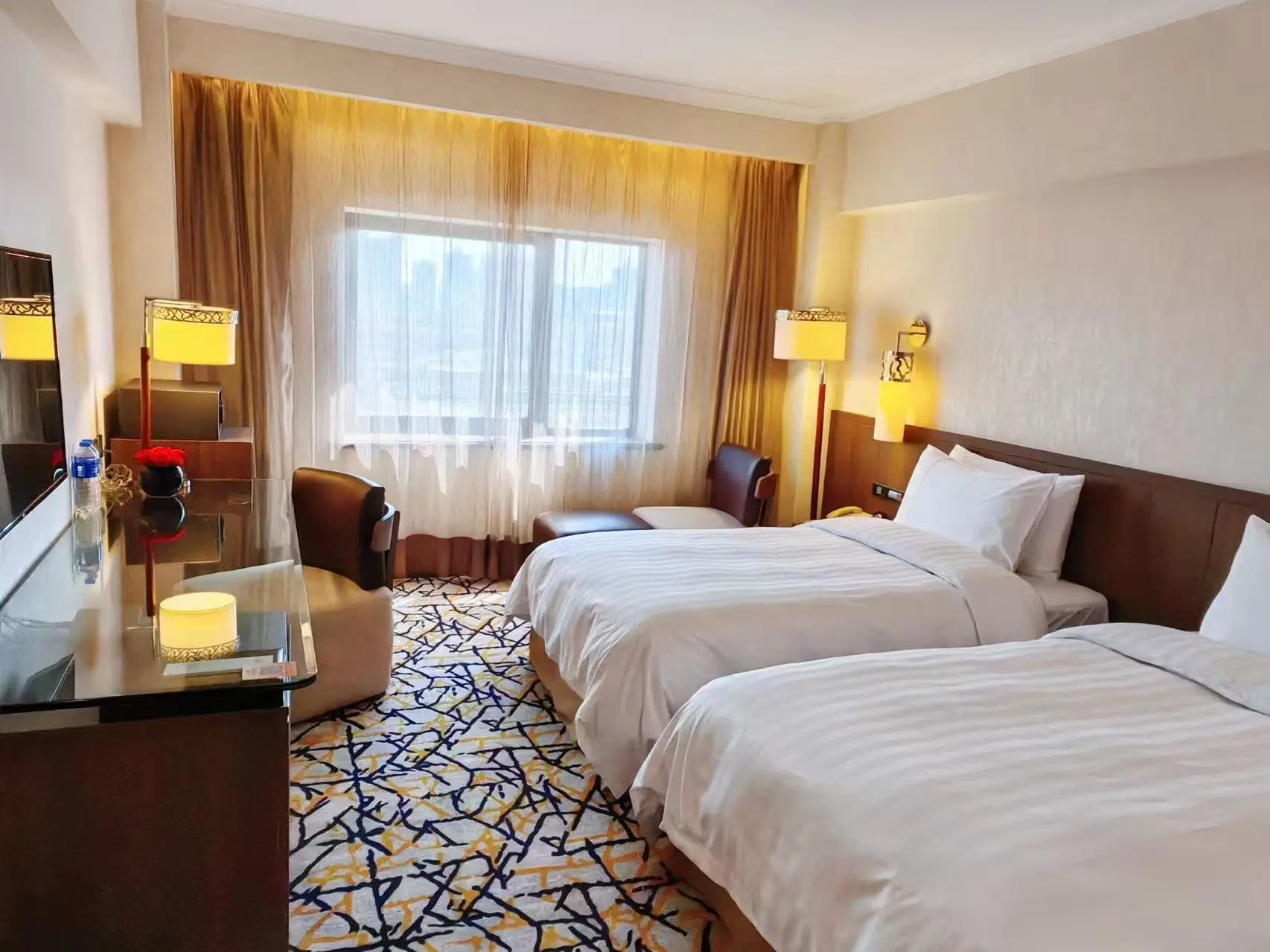 Spacious hotel room with twin beds, neutral décor and warm furnishings at the Grand Noble Hotel Xi’an in Xi’an, China