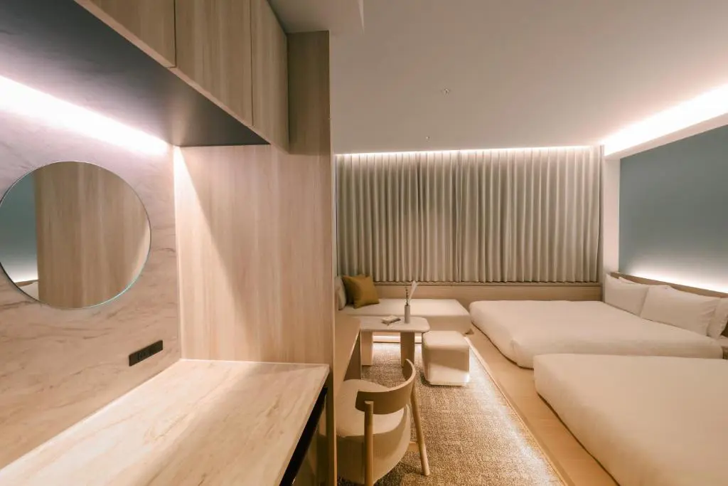 Stylish guest room at FAV LUX Nagasaki with low-profile beds, sleek wooden furniture, and soft curtain lighting