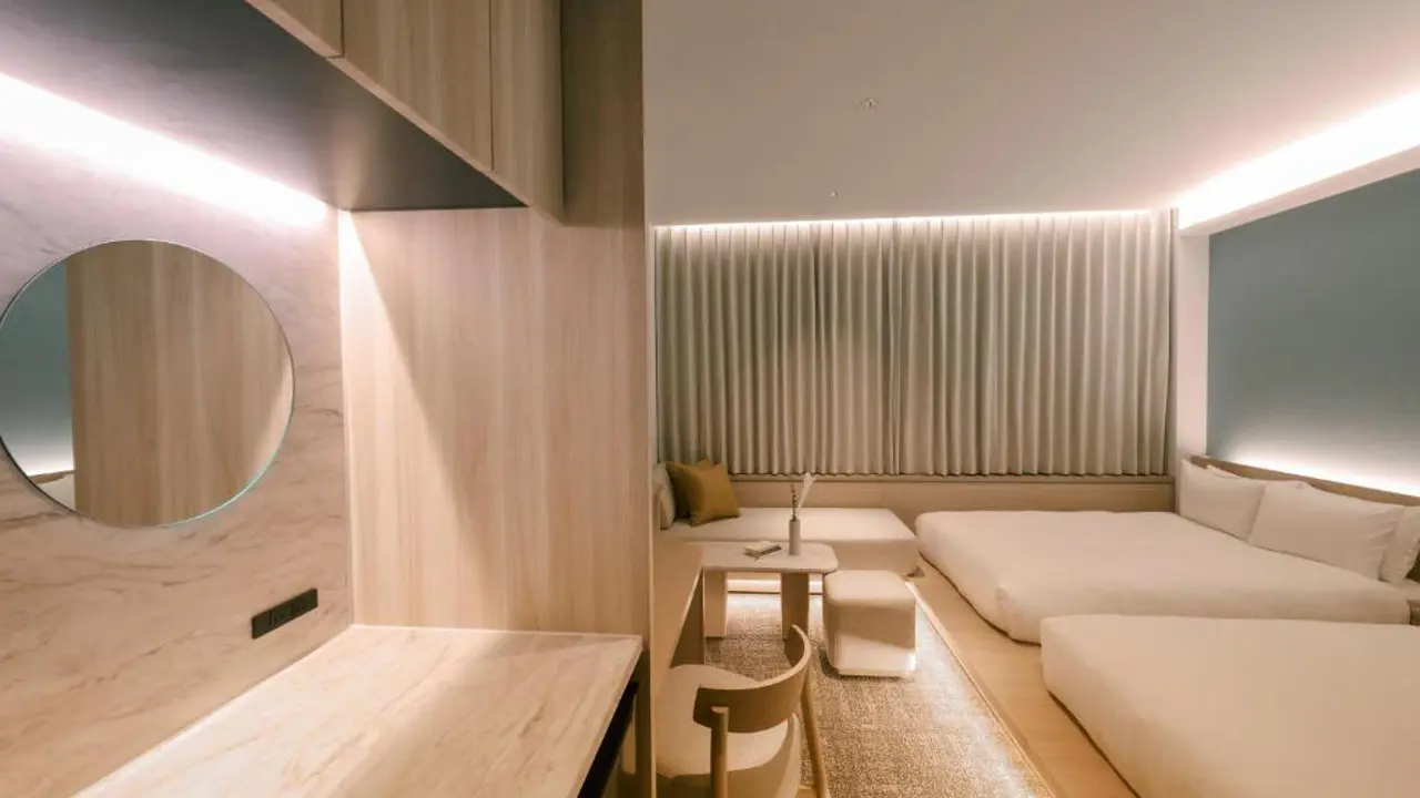 Stylish guest room at FAV LUX Nagasaki with low-profile beds, sleek wooden furniture, and soft curtain lighting