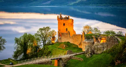 View of Urquhart Castle and Loch Ness, with the sun shining on the castle