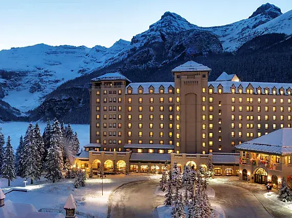 Fairmont Chateau, Lake Louise in winter, set against snowy mountains at sunset