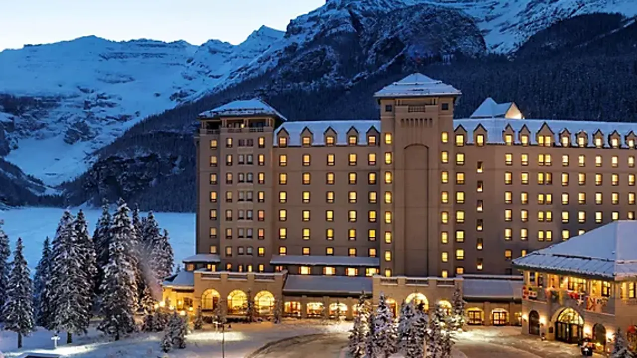 Fairmont Chateau, Lake Louise in winter, set against snowy mountains at sunset