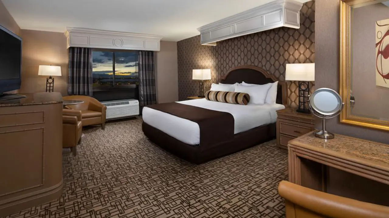 Spacious king room at the Golden Nugget Hotel, Las Vegas, featuring a large bed with white linens, modern furnishings, and warm ambient lighting