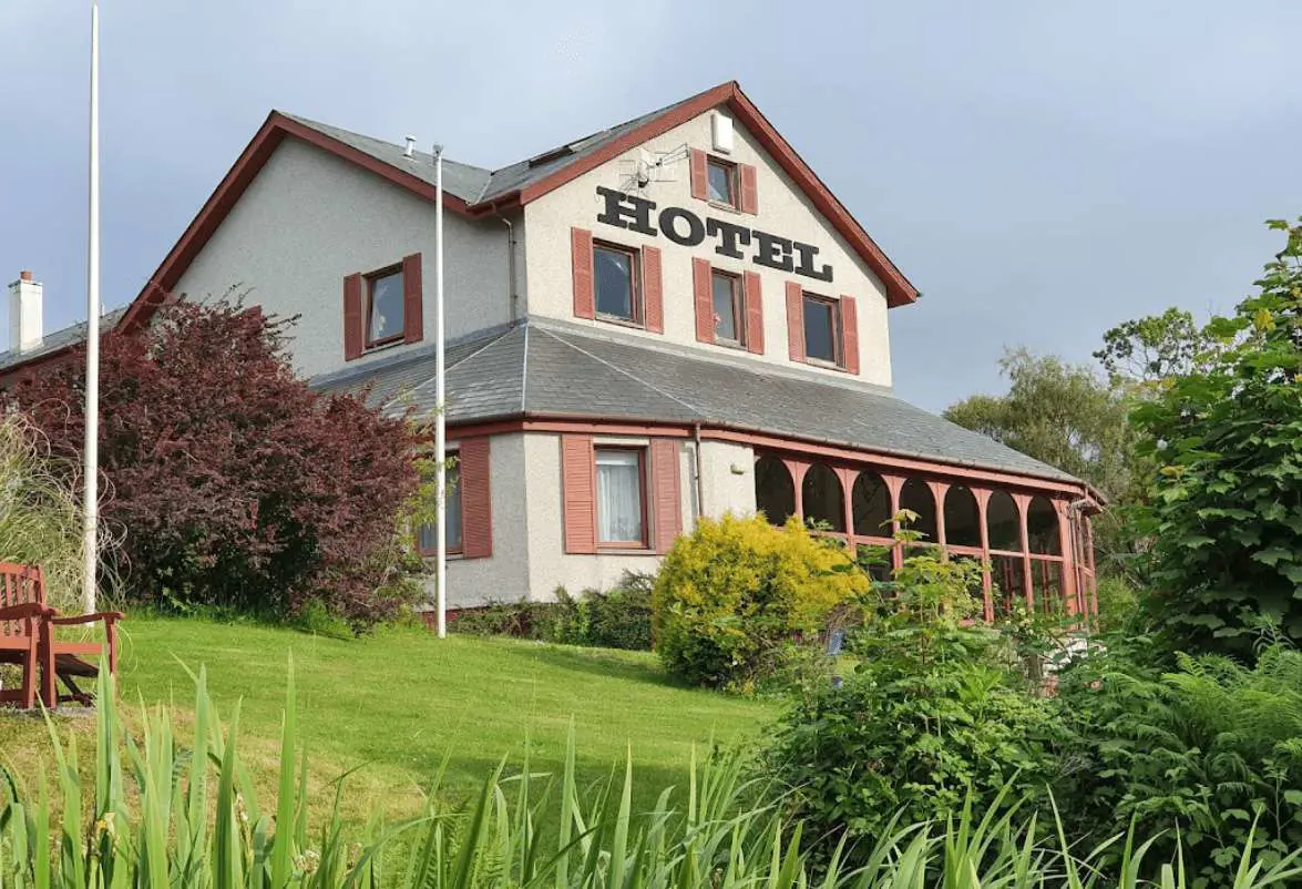 Gairloch Highland Lodge, a charming stone-built hotel set against a well-kept garden, nestled in the scenic surroundings of the Scottish Highlands