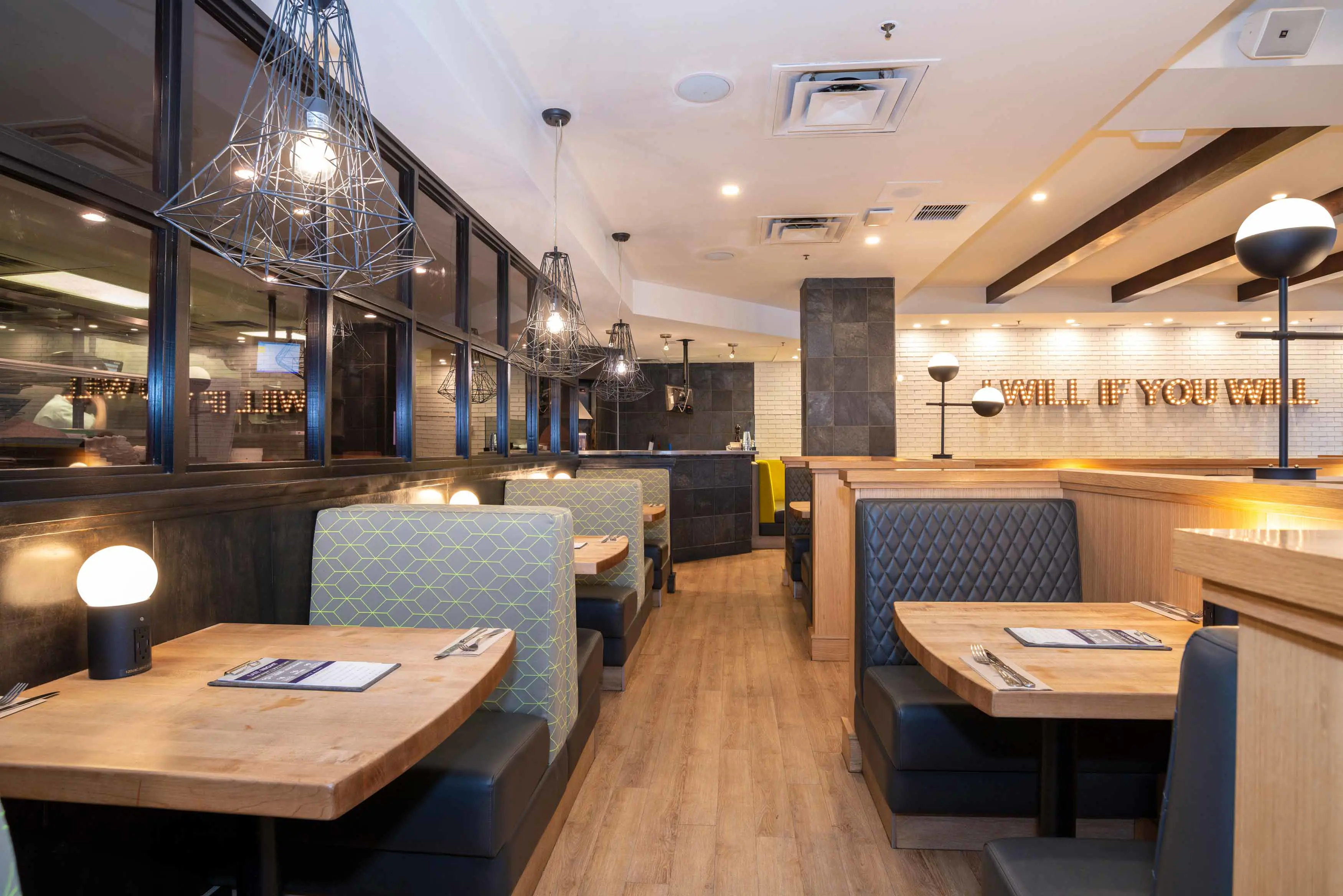 The dining area inside Sandman Signature Calgary Downtown, featuring modern décor, warm lighting, and comfortable seating