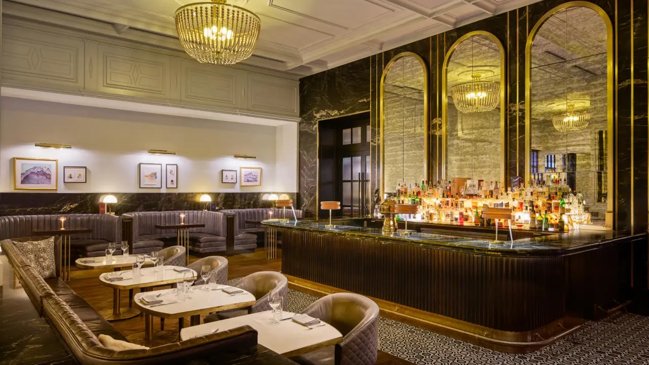 Stylish hotel bar at Fairmont Chateau with marble surfaces, golden accents, and plush seating
