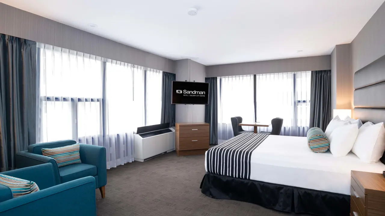 A king room at Sandman Signature Calgary Downtown, featuring a spacious layout and modern furnishings