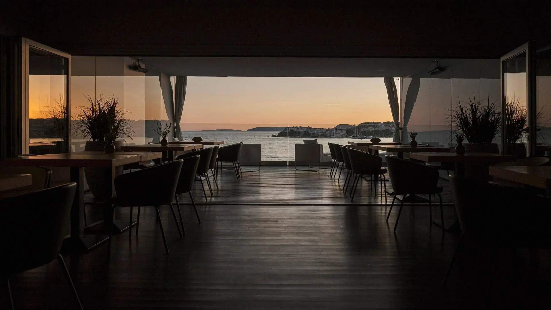 A seafront dining space at Hotel Split, Podstrana, with panoramic sunset views over the Adriatic Sea