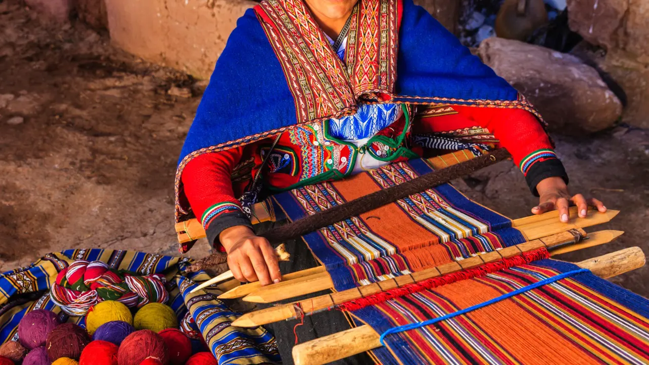 Woman in Peruvian dress weaving, Urubamba Valley