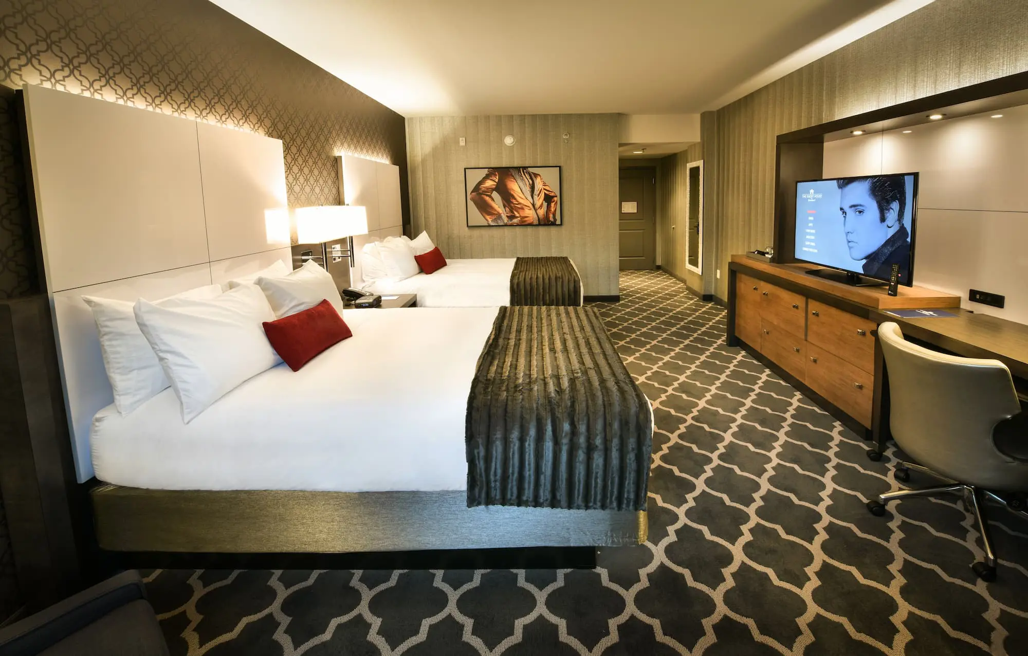 A queen room at The Guest House at Graceland with two queen beds, elegant furnishings, and warm lighting