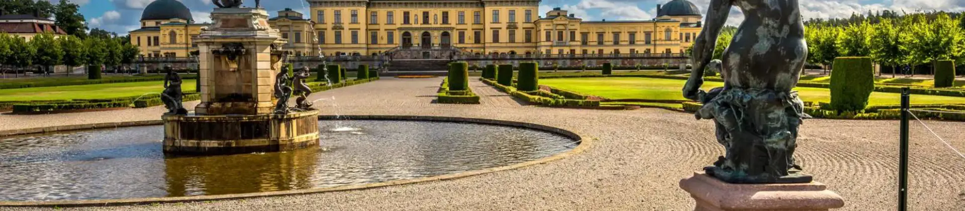 Drottningholm Palace in Sweden, with a central fountain, statues, and formal gardens in front