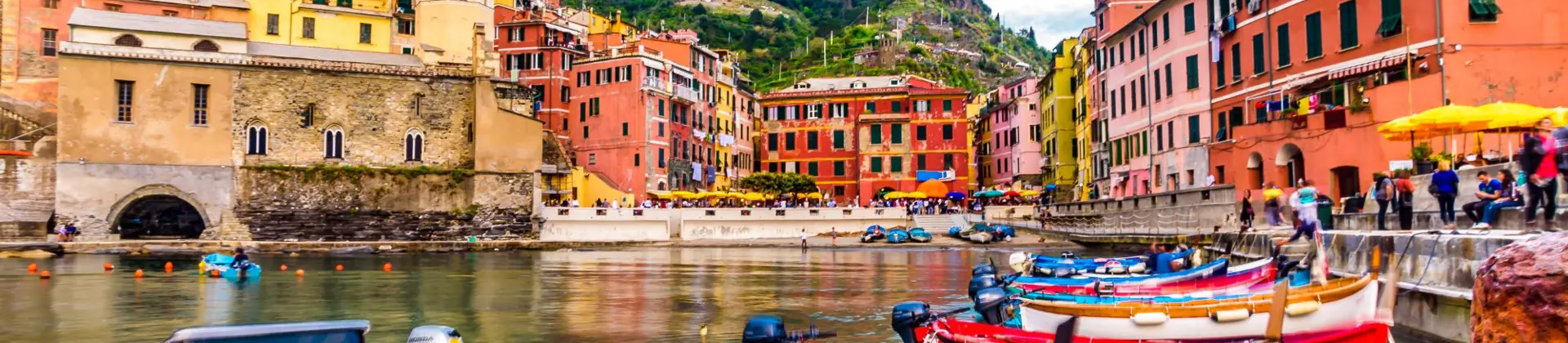 A row of canoes on the water infront of the town of Clinque Terre in Liguria, Italy