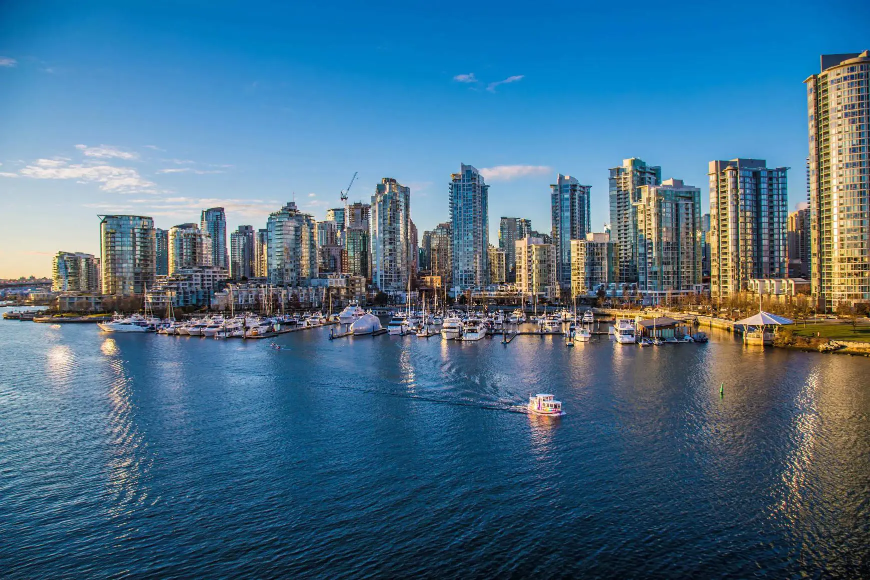 Aerial view of Vancouver Harbour, showing modern high-rise buildings along the waterfront and boats in the harbour