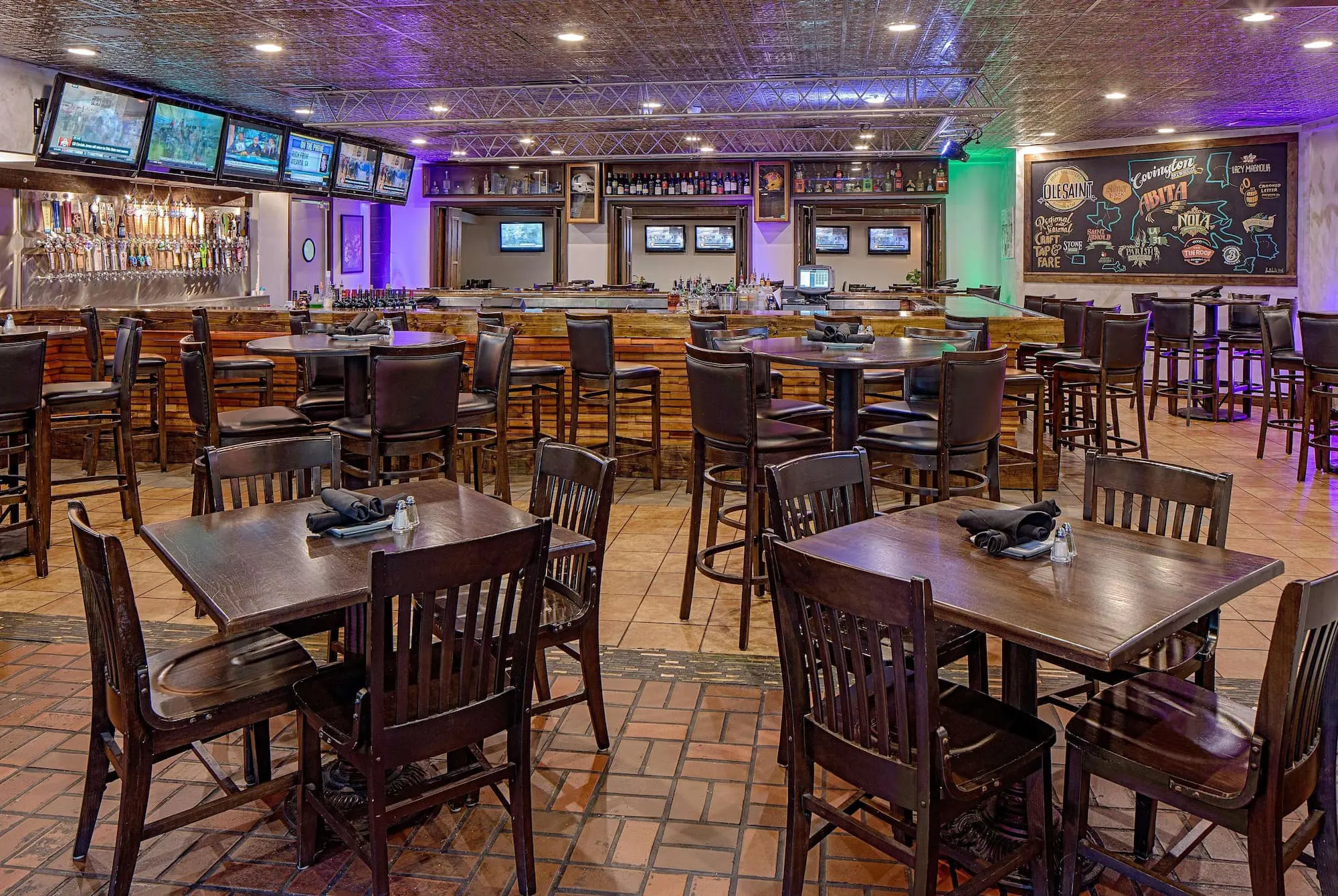 Casual dining area at Wyndham New Orleans French Quarter with wooden tables and chairs, warm lighting, and a relaxed atmosphere