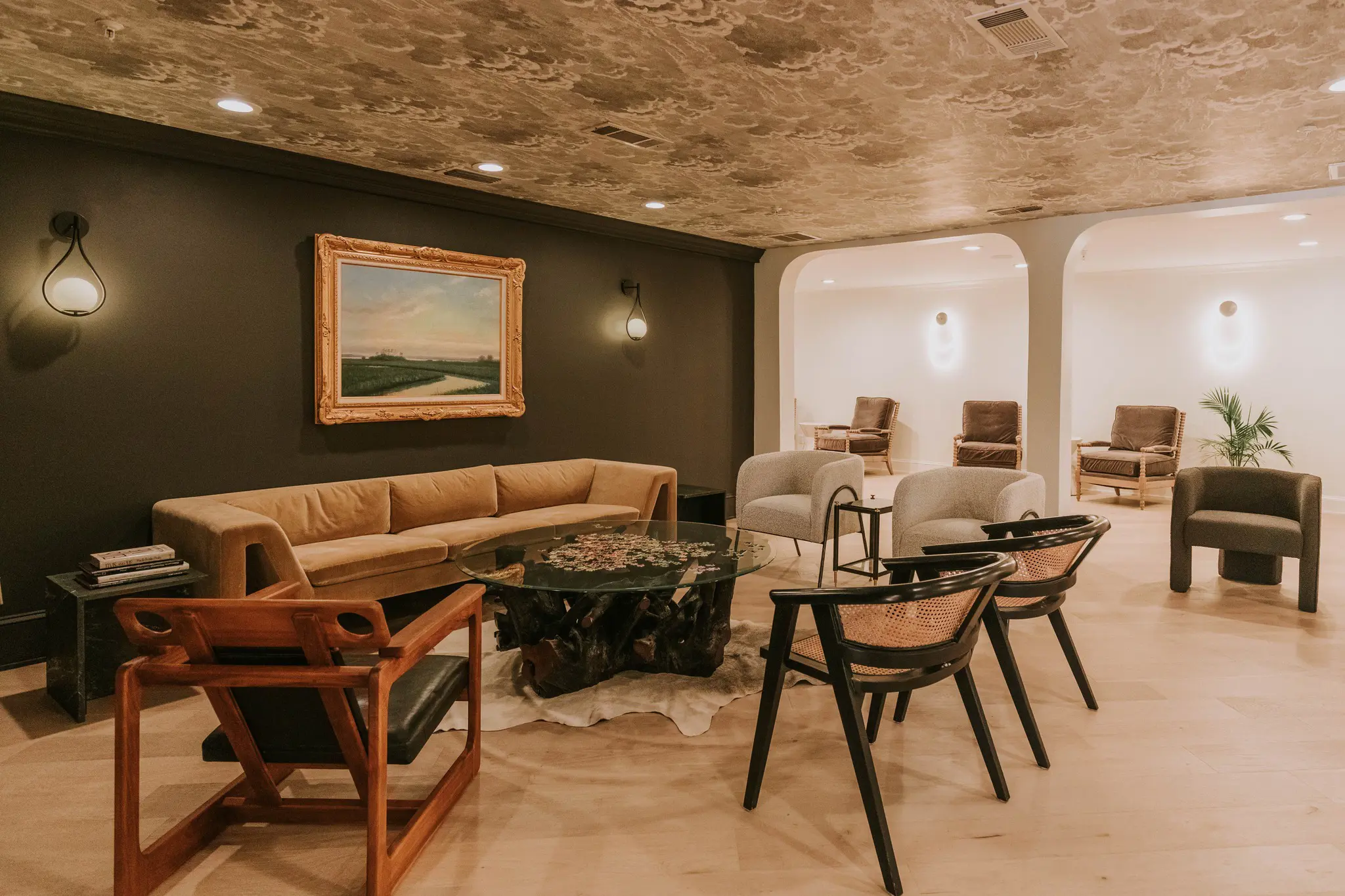 Stylish lounge at Gulf Hills Resort with sofas, armchairs, a black feature wall, and a textured ceiling creating a modern, cosy atmosphere