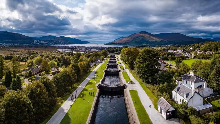 High angle shot of the Caledonian Canal, showing the houses and tress either side and loch and mountains in the distance