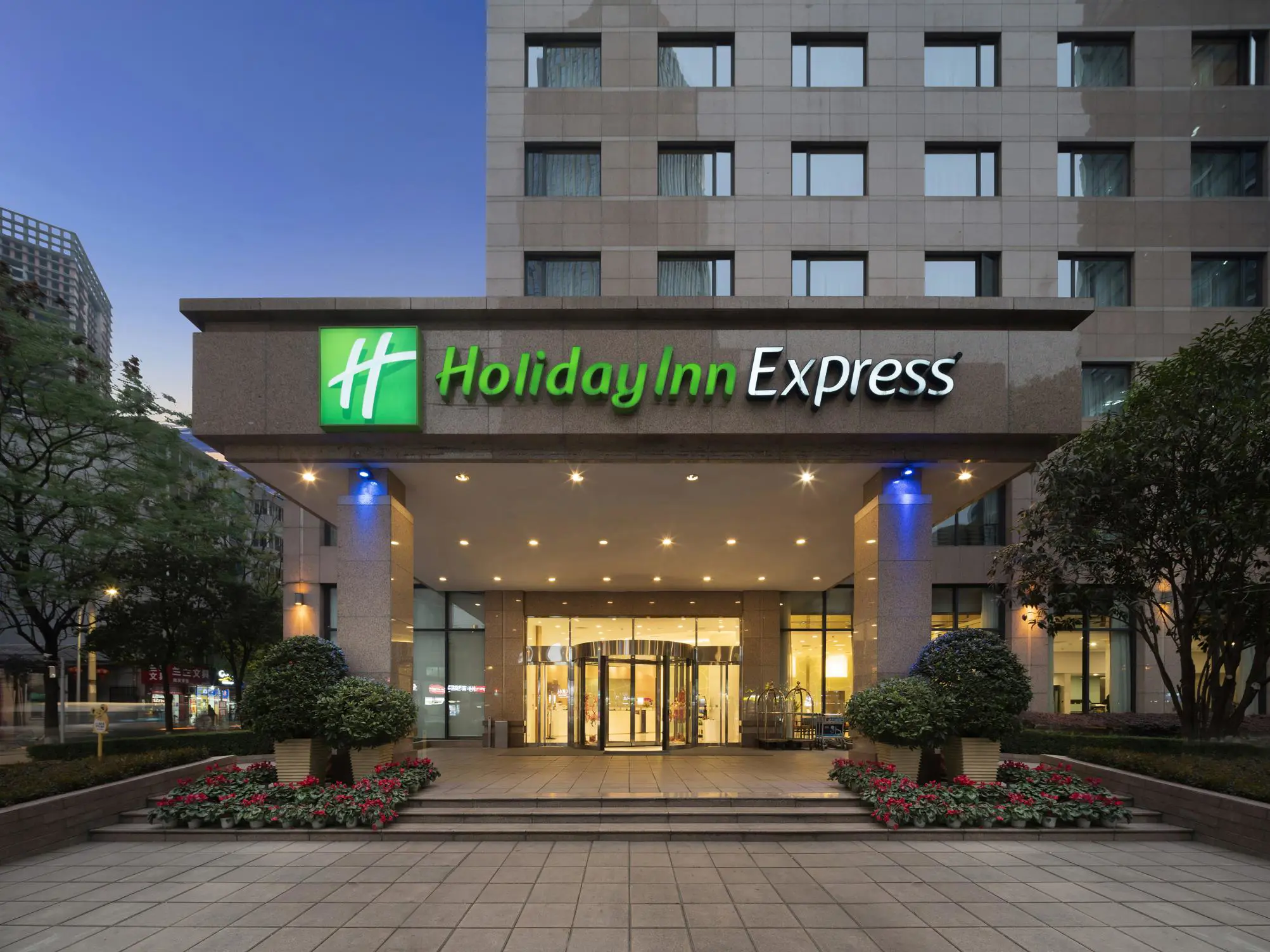 Exterior view of the Holiday Inn Express Beijing Gulou Hotel illuminated at dusk in Beijing, China