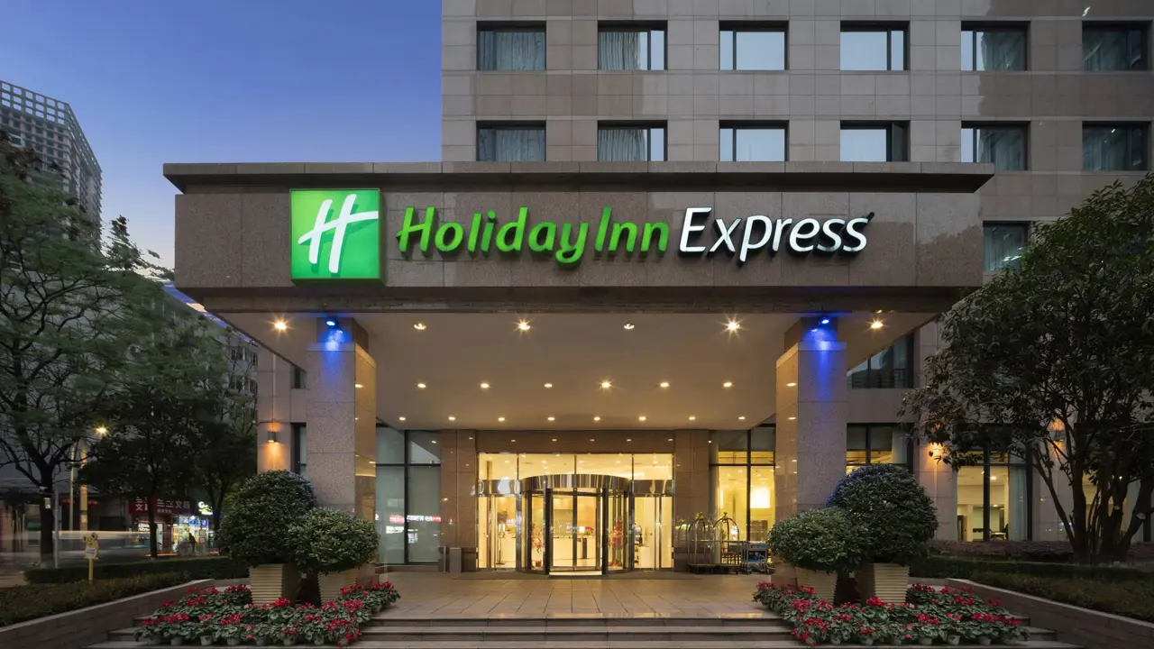Exterior view of the Holiday Inn Express Beijing Gulou Hotel illuminated at dusk in Beijing, China