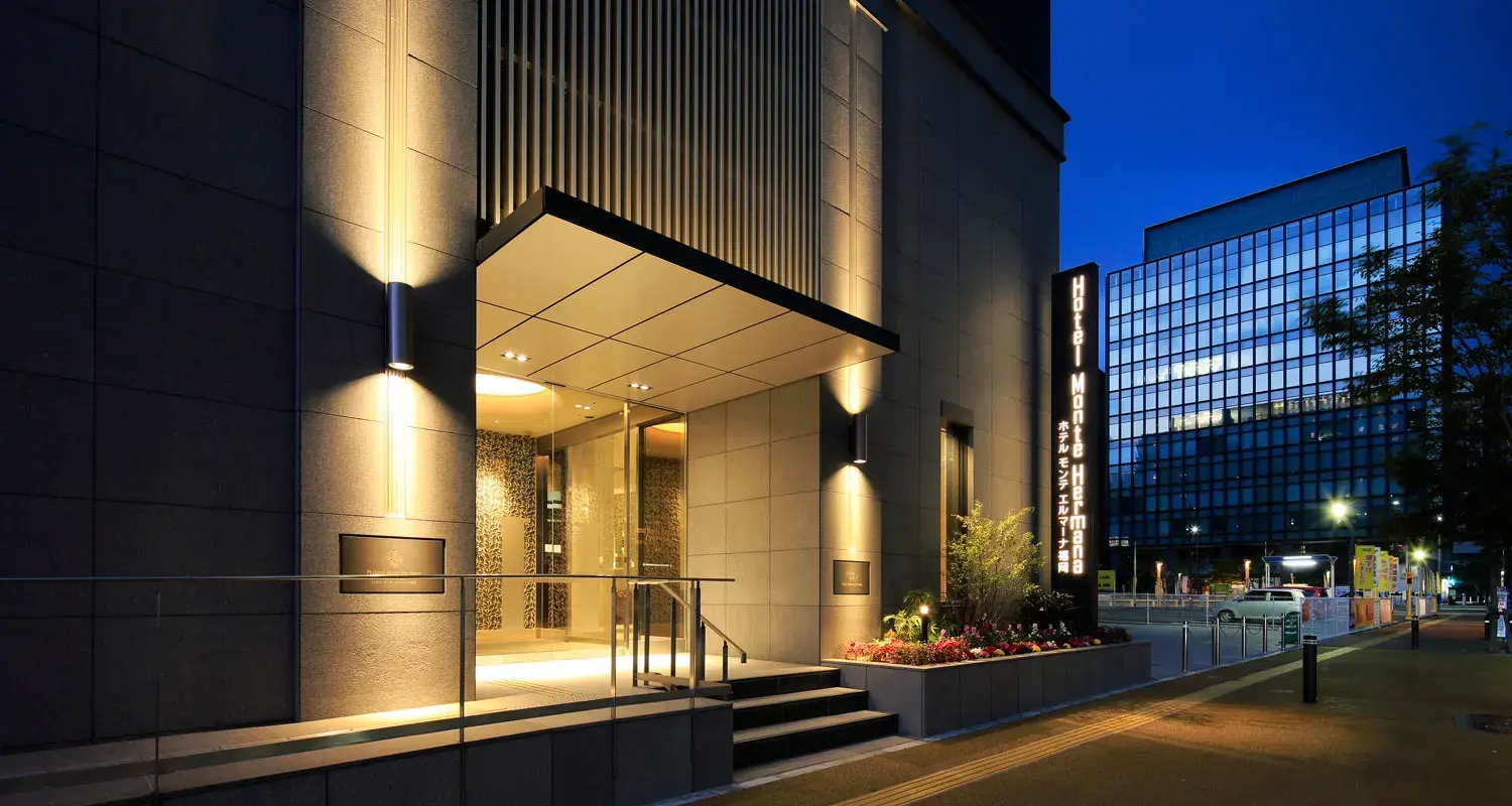 Exterior of Hotel Monte Hermana in Fukuoka, a modern high-rise building with a sleek façade and large windows, set in an urban cityscape