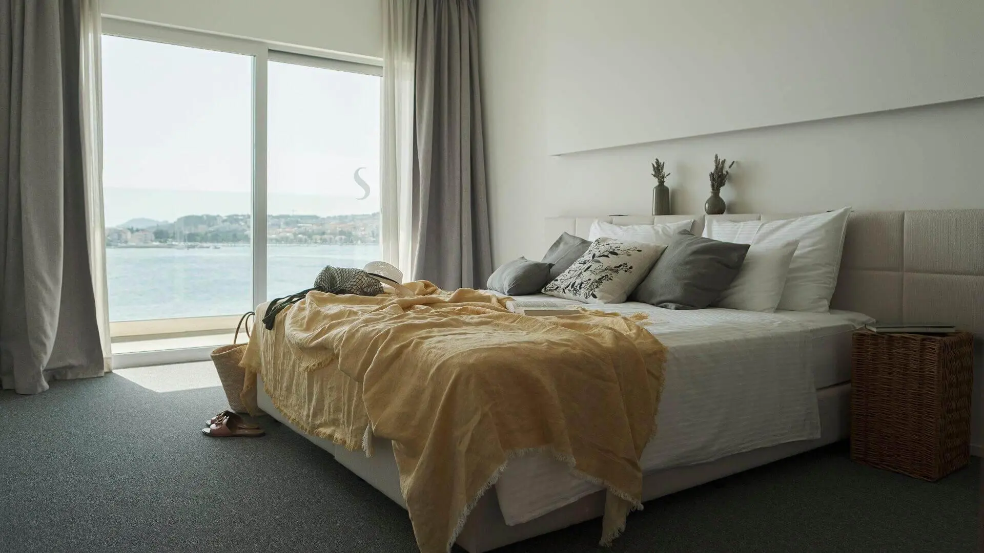 A bright, modern bedroom at Hotel Split, Podstrana, featuring sea views through floor-to-ceiling windows
