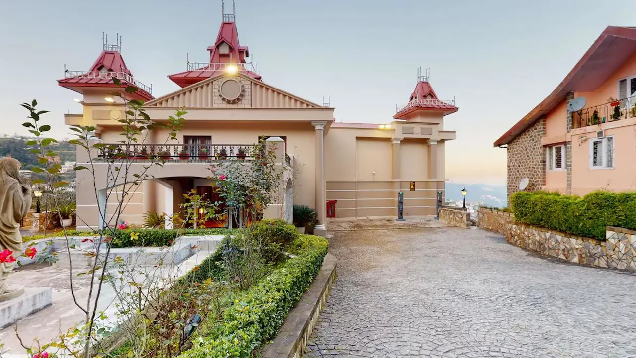 The hilltop exterior of Radisson Hotel Jass in Shimla with red-roofed towers and landscaped gardens