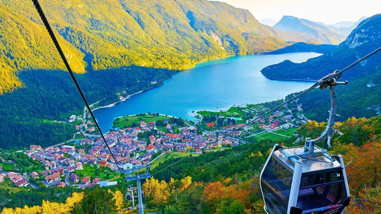 High angle view of the village of Molveno and Lake Molveno in Italy with a cable car in the forefront and the Dolomites in the background