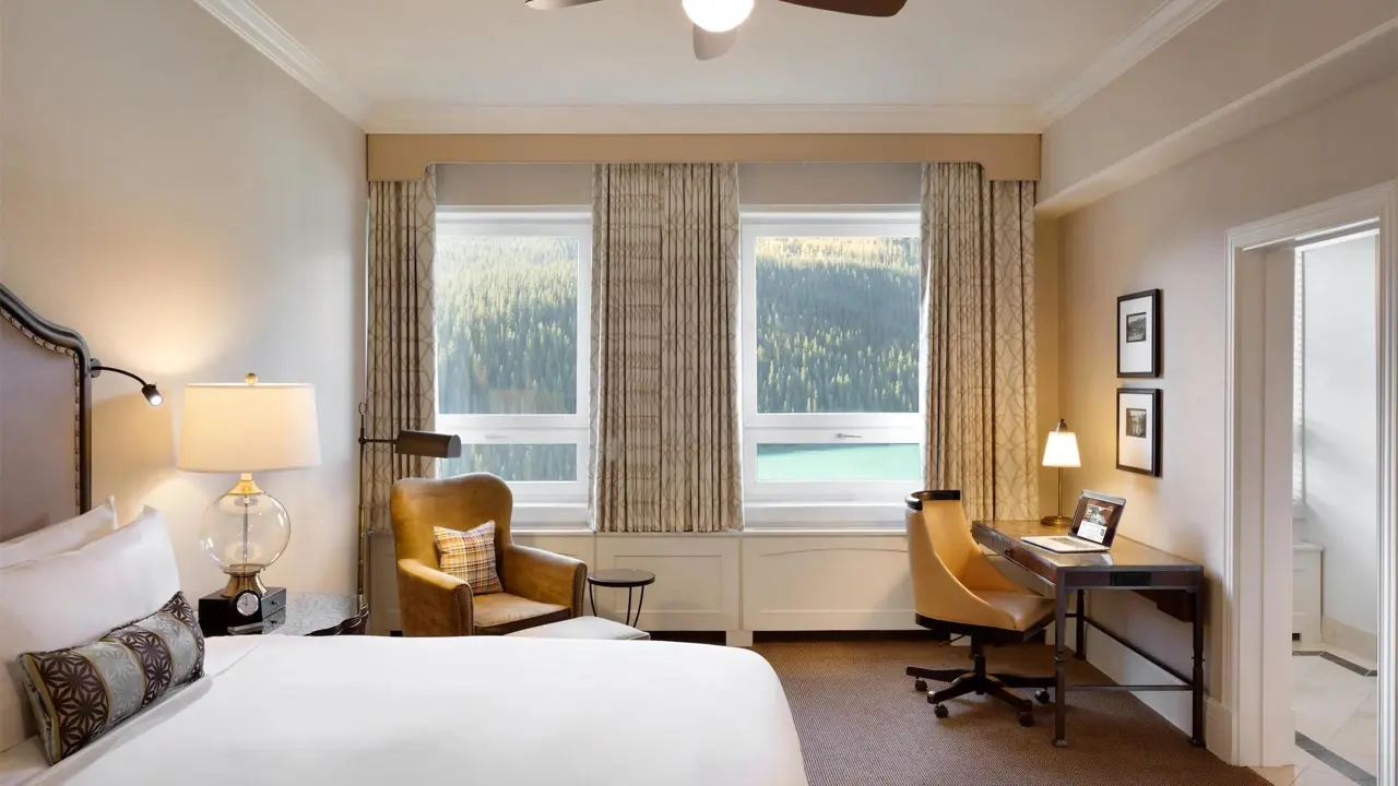 A king room at Fairmont Chateau, Lake Louise with warm décor and views of the surrounding mountains