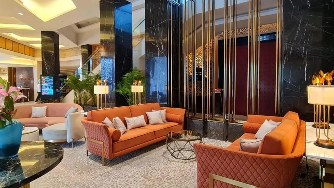 The elegant lobby of the InterContinental Jaipur featuring orange sofas, marble columns and gold accents