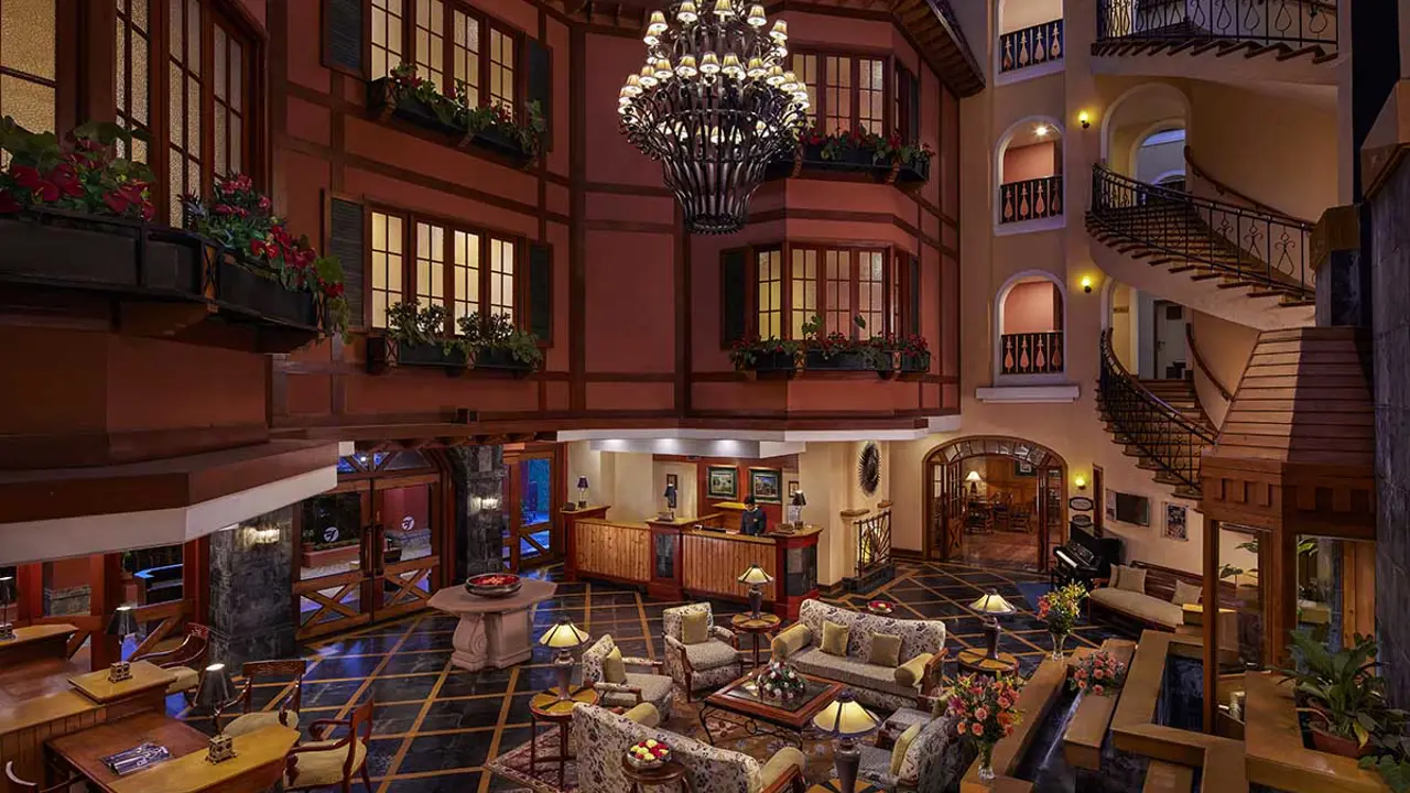 Spacious lobby at Fortune Resort Sullivan Court in Ooty, featuring warm lighting, comfortable seating, and elegant wooden furnishings