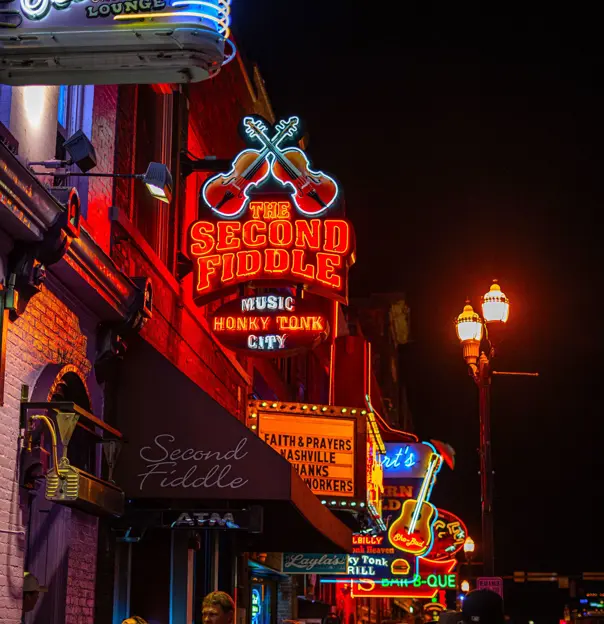 The Second Fiddle, a classic blues bar on Beale Street in Memphis, featuring a vintage neon sign and a lively entrance with people gathered outside