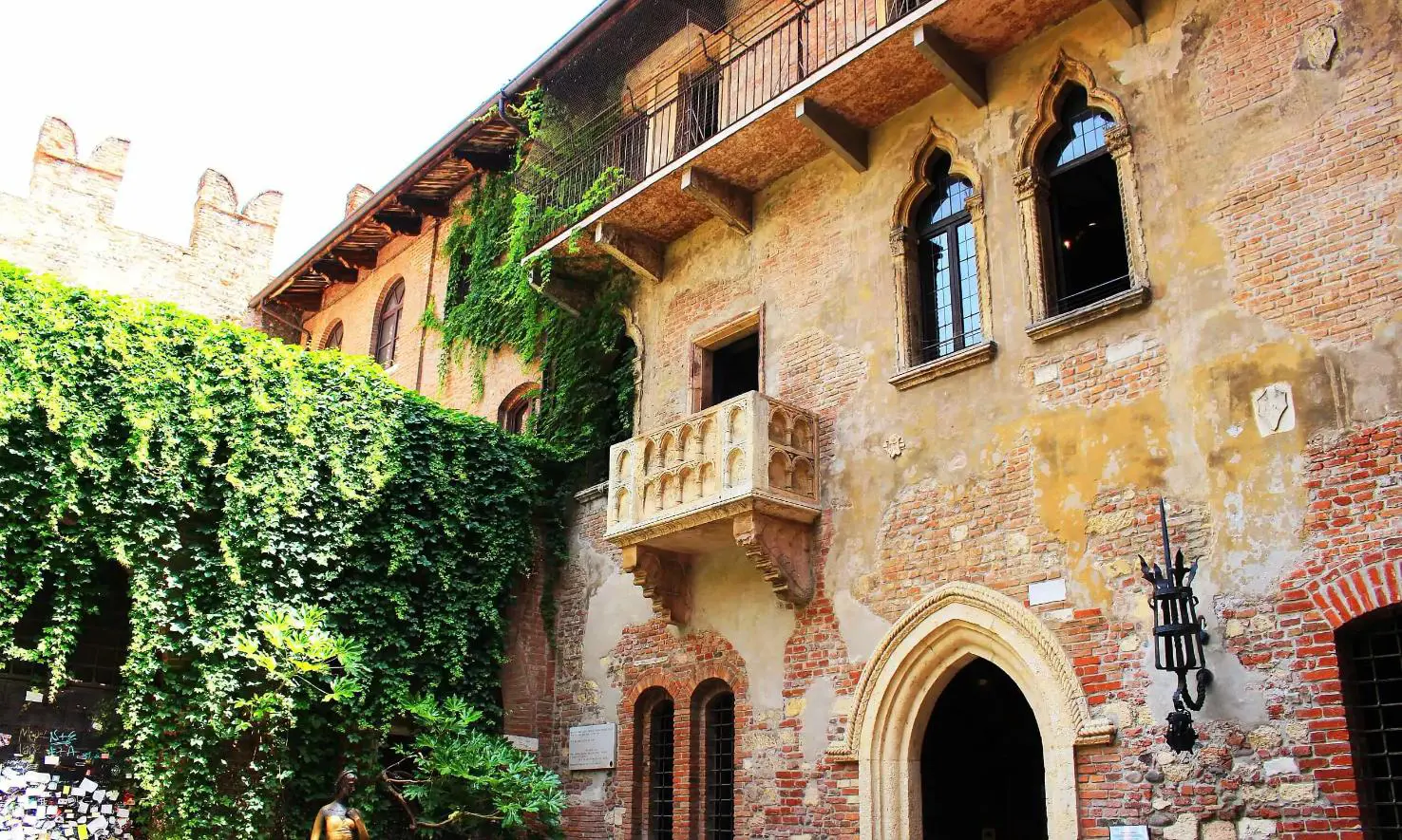 Juliet's Balcony on a brick and stucco building in Verona, Italy, with arched windows and doors, inspired by Shakespeare's Romeo and Juliet