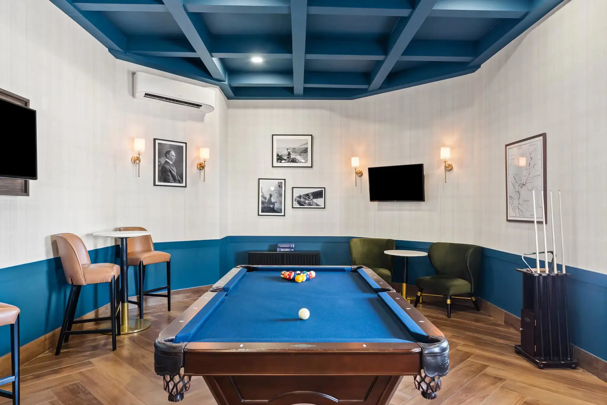 Interior of a cosy game room at The Ellsworth Hotel, featuring a pool table, arcade games, and comfortable seating, with warm lighting creating a fun and inviting atmosphere