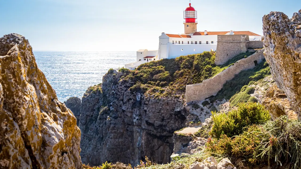 Rocky landscape at Cape St. Vincent on the Algarve, with the lighthouse visible in the distance.