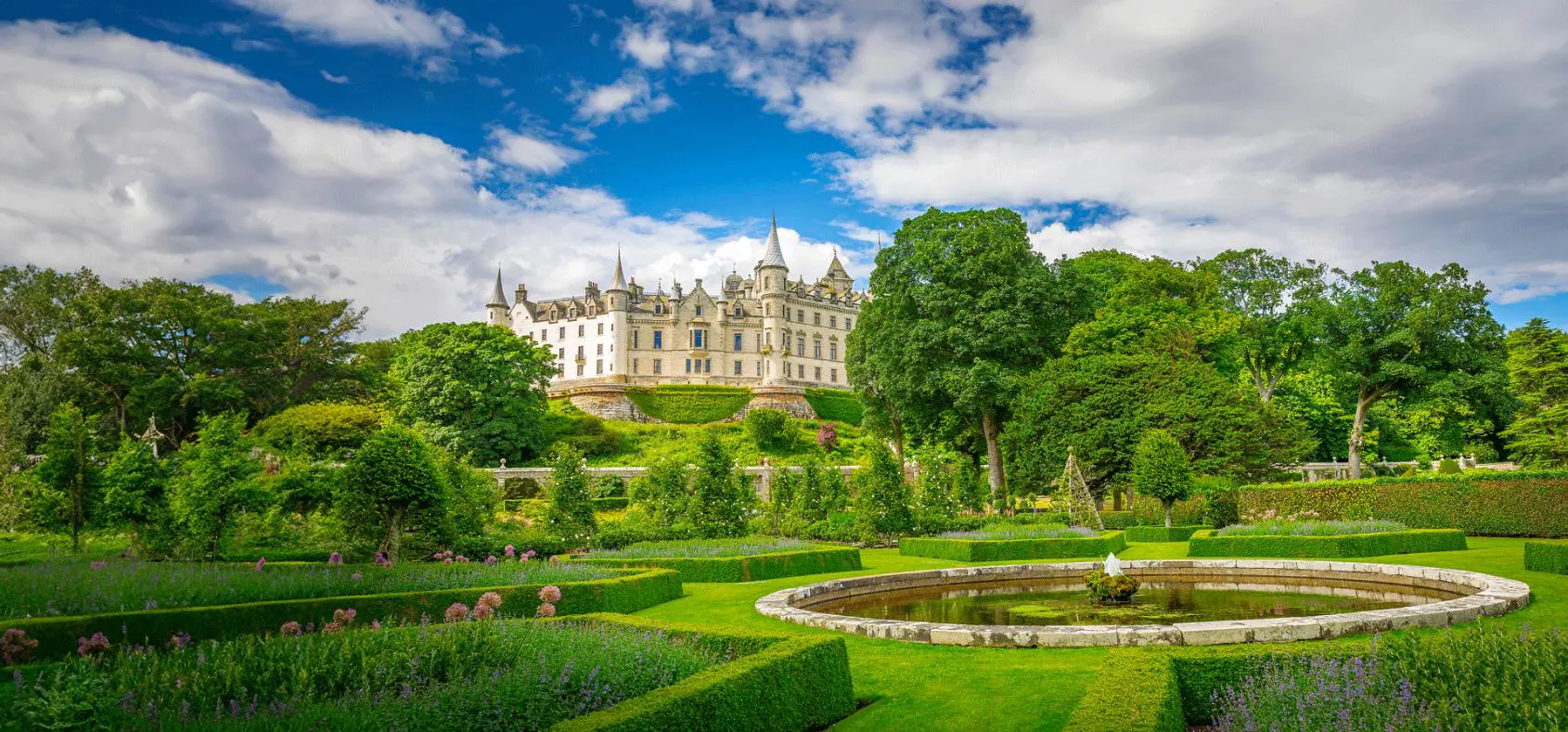 A view of historic Dunrobin Castle in Scotland, with its tall spires and turrets