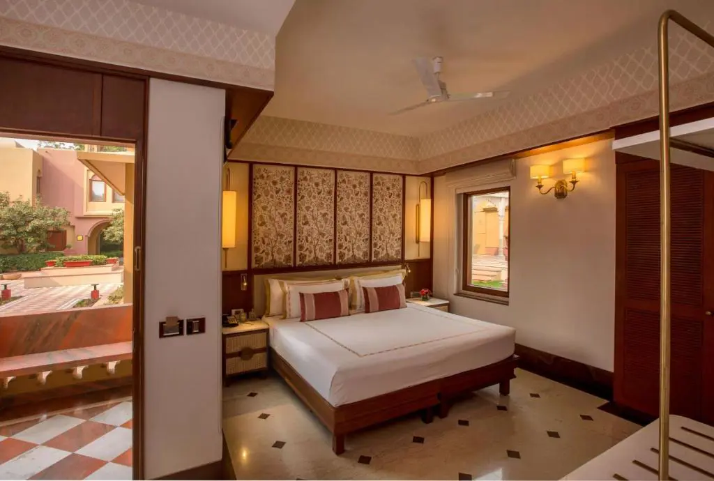 A cosy double room at Heritage Village Resort and Spa in Gurugram, featuring traditional décor, wooden furniture and soft lighting