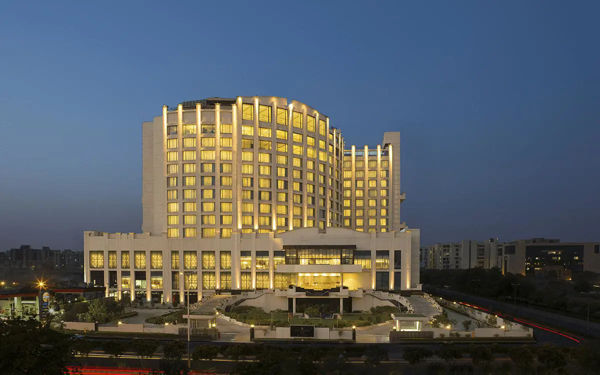 The illuminated exterior of WelcomHotel by ITC in Dwarka with its tiered architecture at dusk