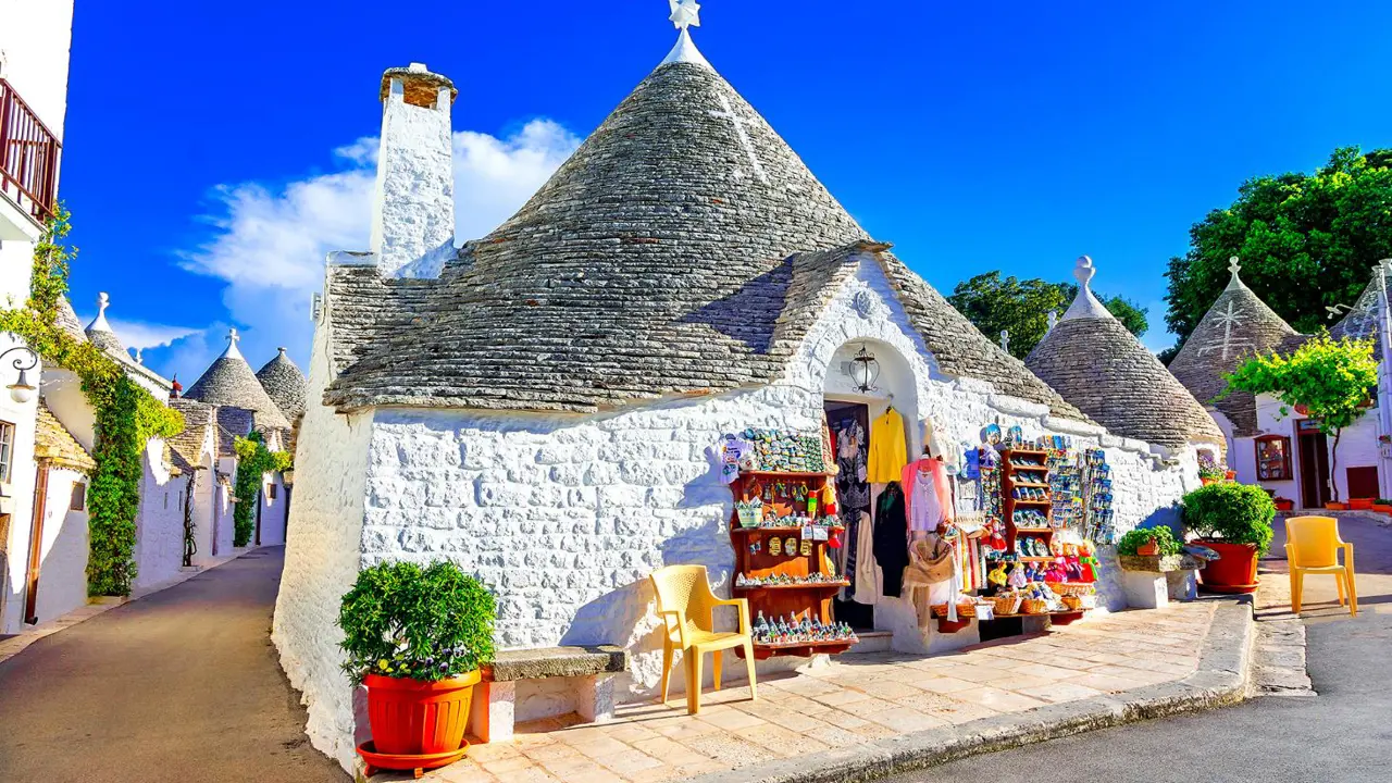 Traditional whitewashed, cone-roofed houses, lined along a narrow street in Alberobello, Puglia