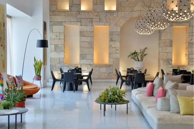 Elegant hotel lobby with marble floors, plush seating, and warm lighting at the Athenaeum Grand Hotel, Athens